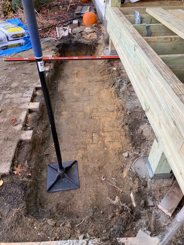 Pressure-treated deck framing beside a prepared footing trench